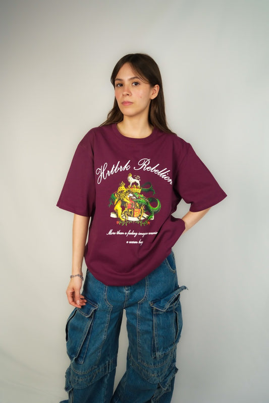 A girl wearing a dark red shirt with a big green logo of a lion that represents a streetwear shop in Calgary called HRTBRK