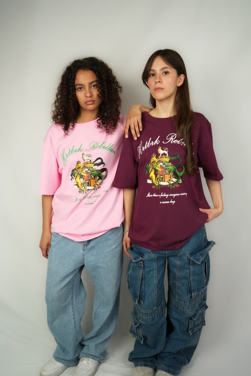 Two people wearing colorful graphic t-shirts and jeans against a plain background