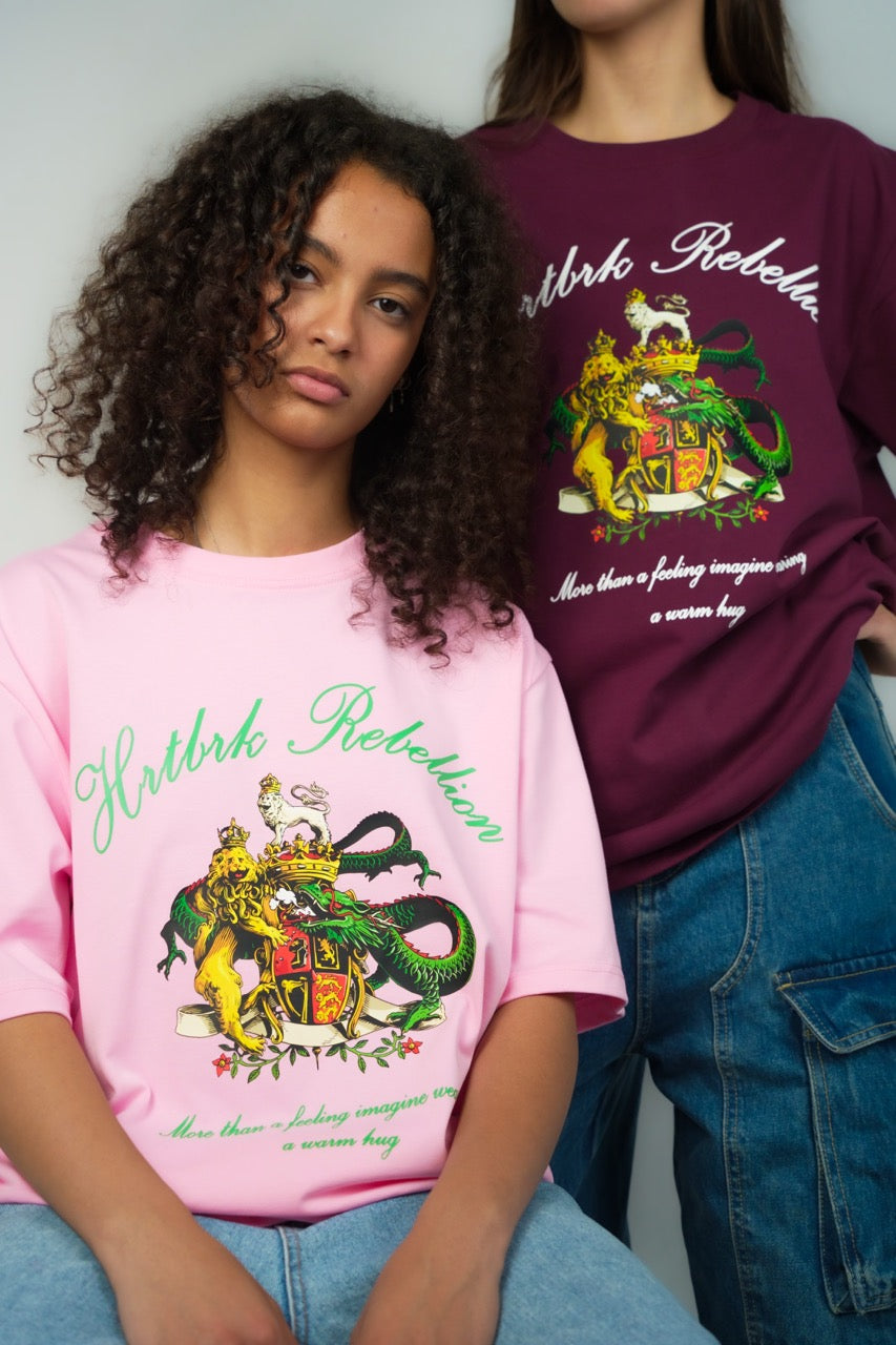 two people wearing a Calgary clothing brand called HRTBRK, the design contains a dragon with a lion. with the words "hrtbrk rebelion"
